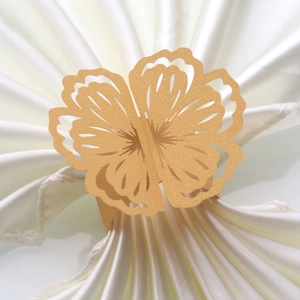 Detail of laser-cut butterfly napkin ring in gold pearlescent paper for weddings