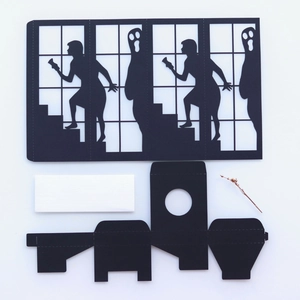 DIY Halloween paper lantern kit featuring black ghost silhouettes and cut-out window frames