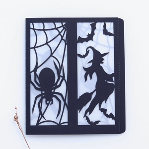 Detailed laser cut spider web and witch design on black Halloween cardstock covers