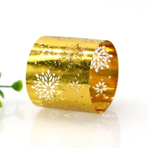 Close-up of golden metal snowflake napkin ring with laser glitter finish and cutout design