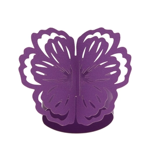 Detail of laser-cut purple flower napkin ring with intricate hollowed-out floral pattern