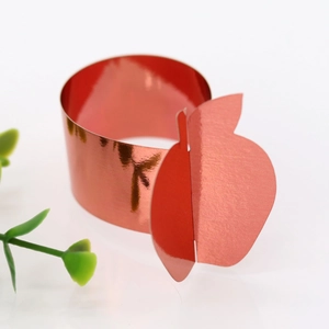 Detail of red apple-shaped napkin ring with a glossy metallic finish for Thanksgiving
