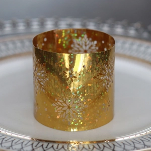 Macro shot of gold hollow laser-cut snowflake napkin ring with holographic finish