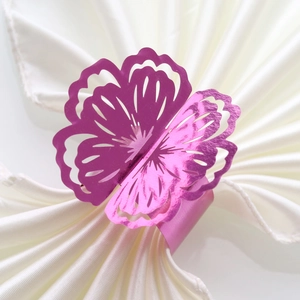 Close-up of laser-cut flower napkin ring in purple metallic finish for weddings