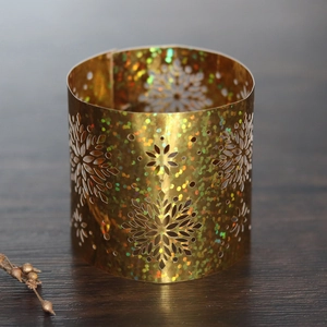 Close-up of golden laser-cut snowflake napkin ring with shimmering iridescent finish