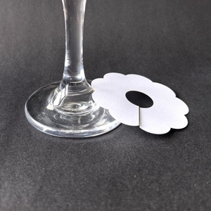 White flower-shaped paper wine glass place cards for wedding table name settings