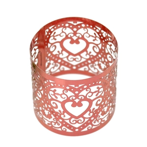 Detail showing the intricate laser-cut heart and scroll texture on the rose gold napkin ring