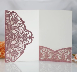 Detail view of rose gold laser-cut lace wedding invitation with glitter texture