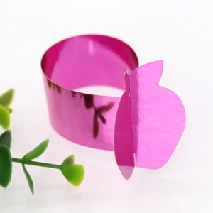 Detail of rose red mirror-finish apple napkin ring with fine textured metallic surface
