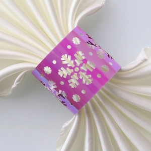 Macro detail of laser-cut snowflake napkin ring with iridescent holographic finish