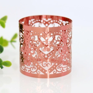 Detail shot of rose gold heart cutout napkin ring with elegant floral scroll patterns