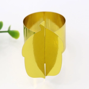 Detail shot of golden leaf-shaped napkin ring with a polished mirror finish for dining decor