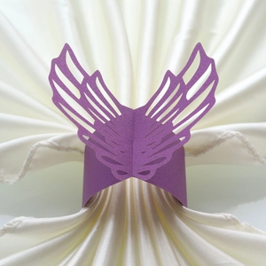 Macro shot of laser-cut purple pearlescent paper napkin ring in butterfly wing design