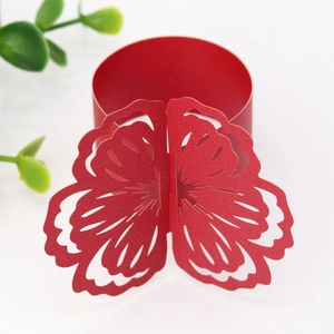 Detail of red laser-cut floral paper napkin ring for wedding and festive table decor