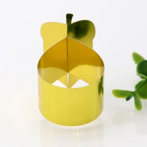 Macro shot of mirror-finish gold apple-shaped paper napkin ring for holiday table decor