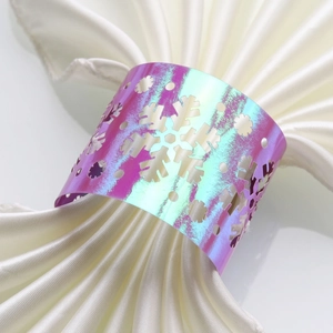 Macro detail of holographic snowflake napkin ring with intricate laser-cut patterns