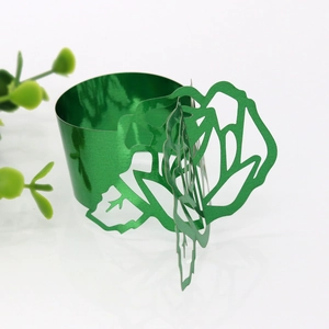 Close-up of green laser-cut metal napkin ring with elegant floral hollow design