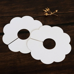 Detail of petal-shaped white paper card for wine glass stem decoration on wood background