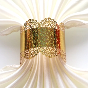 Close-up of golden lace napkin ring with sparkling glitter detail on white fabric
