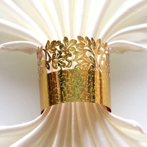 Close-up of golden leaf napkin ring with holographic glitter for wedding table decor