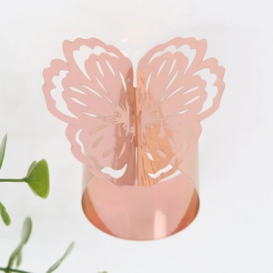 Detailed view of rose gold butterfly napkin ring with laser-cut hollow wing textures