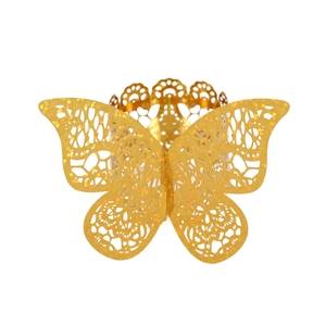 Macro shot of gold laser-cut butterfly napkin ring with glitter texture and floral pattern