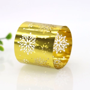 Detail of golden napkin ring featuring laser-cut snowflake patterns for holiday decor