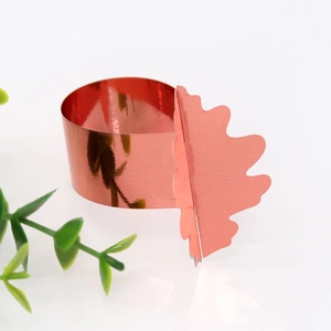 Gros plan d'un rond de serviette rouge brillant avec détail de feuille de chêne festif
