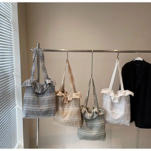 Série de sacs cabas en toile à volants aux motifs à carreaux variés sur un support