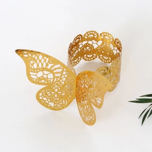 Detail of laser-cut gold butterfly napkin ring showing intricate hollow patterns