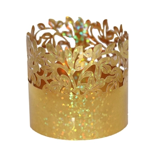 Close-up of golden glitter napkin ring with laser-cut floral texture for wedding party decor