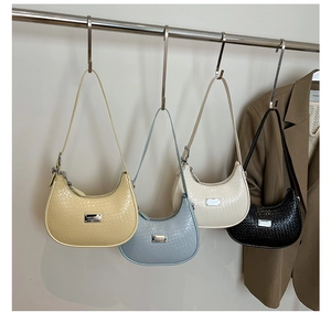Detailed view of crescent shoulder bags featuring woven textures in four elegant pastel colors