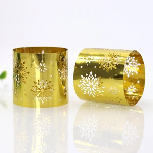 Close-up of golden snowflake napkin rings with hollow design for Christmas table decor