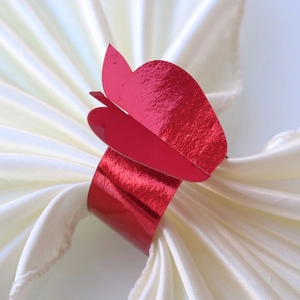 Close-up of elegant red butterfly napkin ring with mirror finish on white fabric