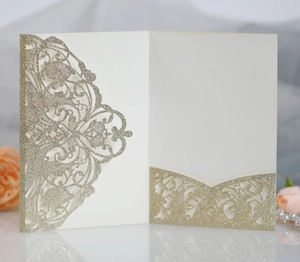 Detailed view of laser-cut lace wedding invitation with glitter gold floral finish