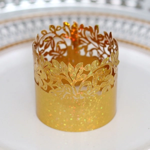 Macro view of gold glitter laser-cut napkin ring with intricate vine leaf hollow patterns