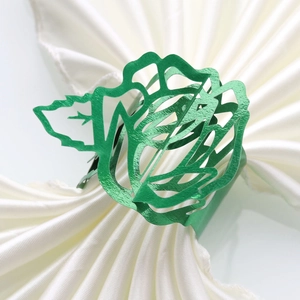 Close-up of green hollow rose napkin ring on a white folded satin napkin for weddings