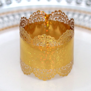Detailed view of golden laser-cut lace napkin ring with sparkling glitter finish for parties