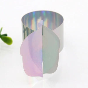 Macro shot of iridescent laser-cut napkin ring showing colorful metallic gradient effects