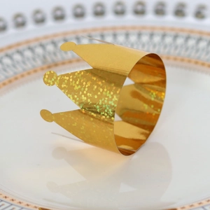 Macro shot of gold glitter crown napkin ring on a white decorative ceramic plate