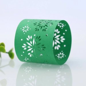 Macro view of green hollowed snowflake paper napkin ring for Christmas table decor