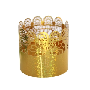 Detail of laser-cut gold lace cupcake wrapper with shimmering glitter crown pattern
