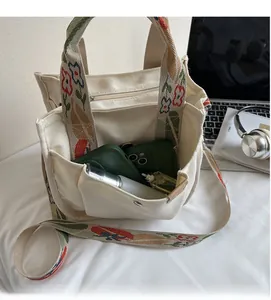 Detailed interior storage of off-white canvas tote with colorful floral embroidery