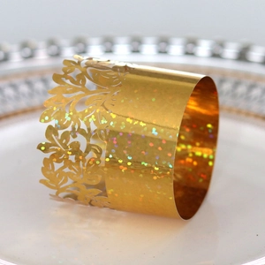 Detail of hollow floral champagne gold napkin ring with sparkling holographic finish