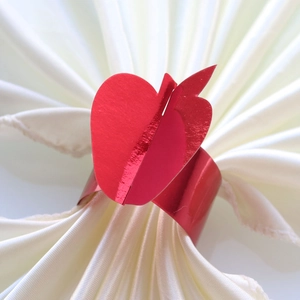 Glossy red apple napkin ring on a white satin napkin for elegant Thanksgiving decor