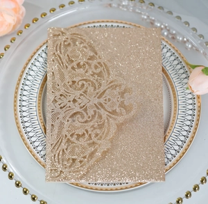 Close-up of laser-cut hollow vine pattern on gold glitter paper wedding invitation card