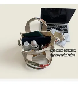 Top view of spacious cream canvas tote interior showing red-green woven handle