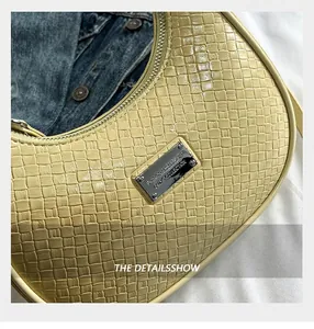 Detail of yellow woven hobo bag showing cross-weave texture and silver logo plaque