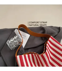 Close-up of red and white striped canvas tote bag with a brown wide shoulder strap