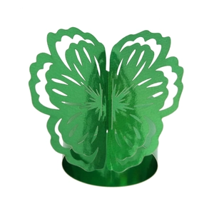 Close-up of green butterfly napkin ring with hollowed floral patterns on white background
